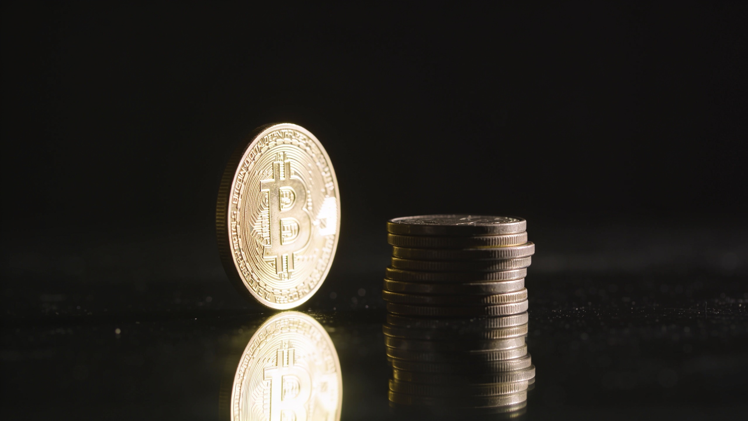 A single glowing coin beside a small stack of coins