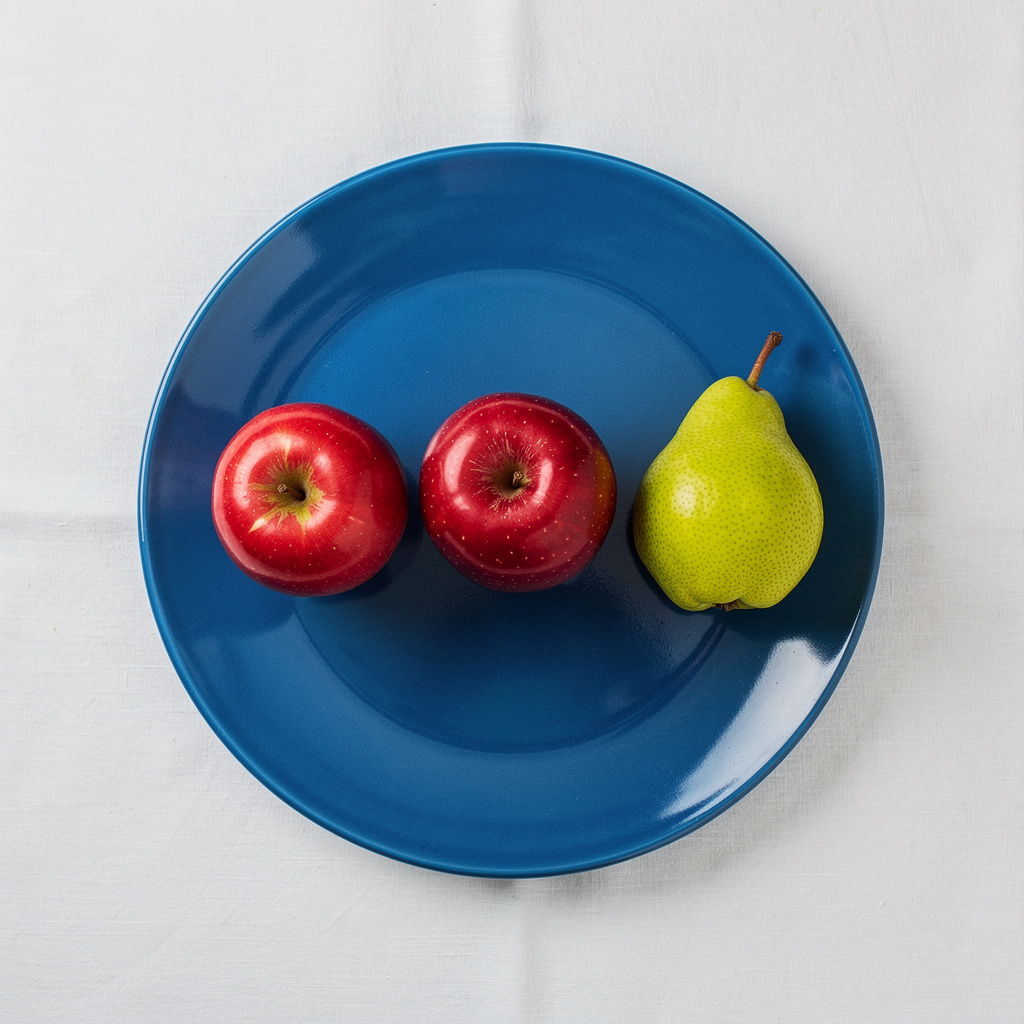 FLUX.2 Pro: Three red apples and one green pear arranged in a single row on a blue plate, top-down view, white tablecloth
