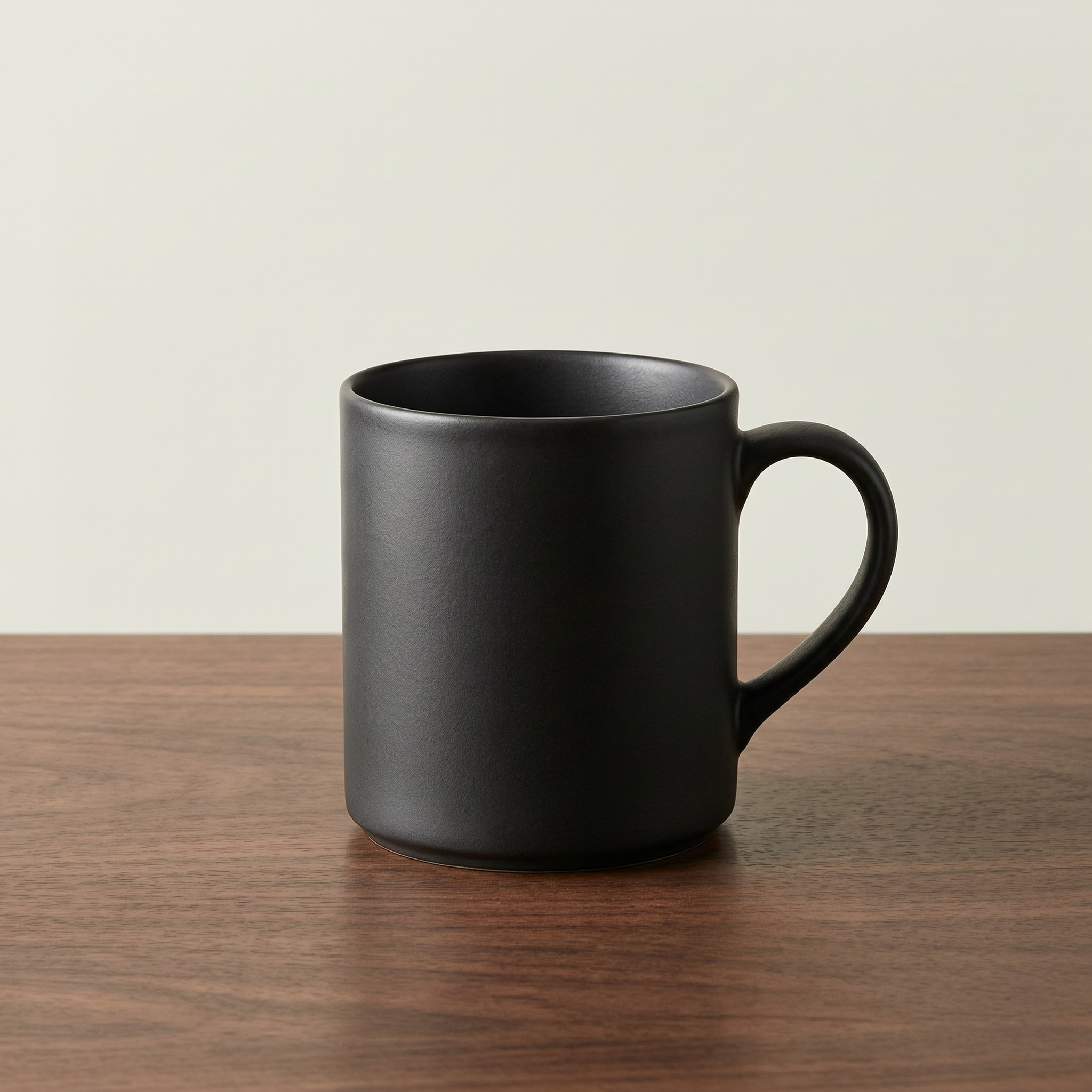 WAN 2.7 Pro: A matte black ceramic coffee mug on a walnut table, single soft light from the left, minimal studio backdrop, product photography