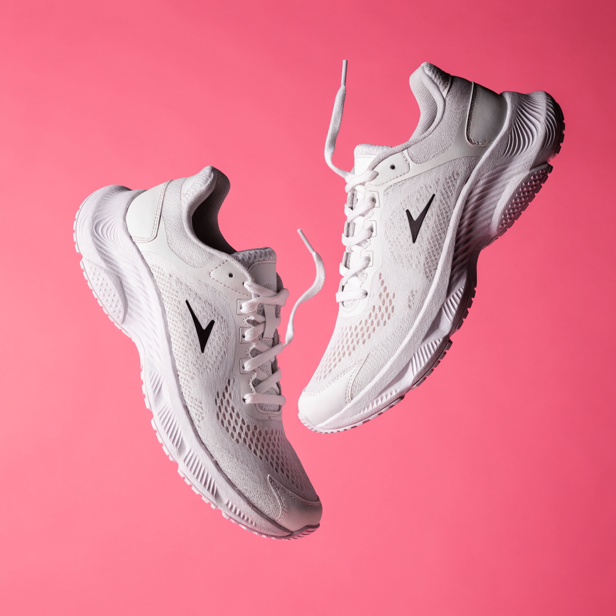 Recraft V4.1 Pro: A pair of white running shoes floating mid-air over a pastel pink background, even studio lighting, catalogue shot