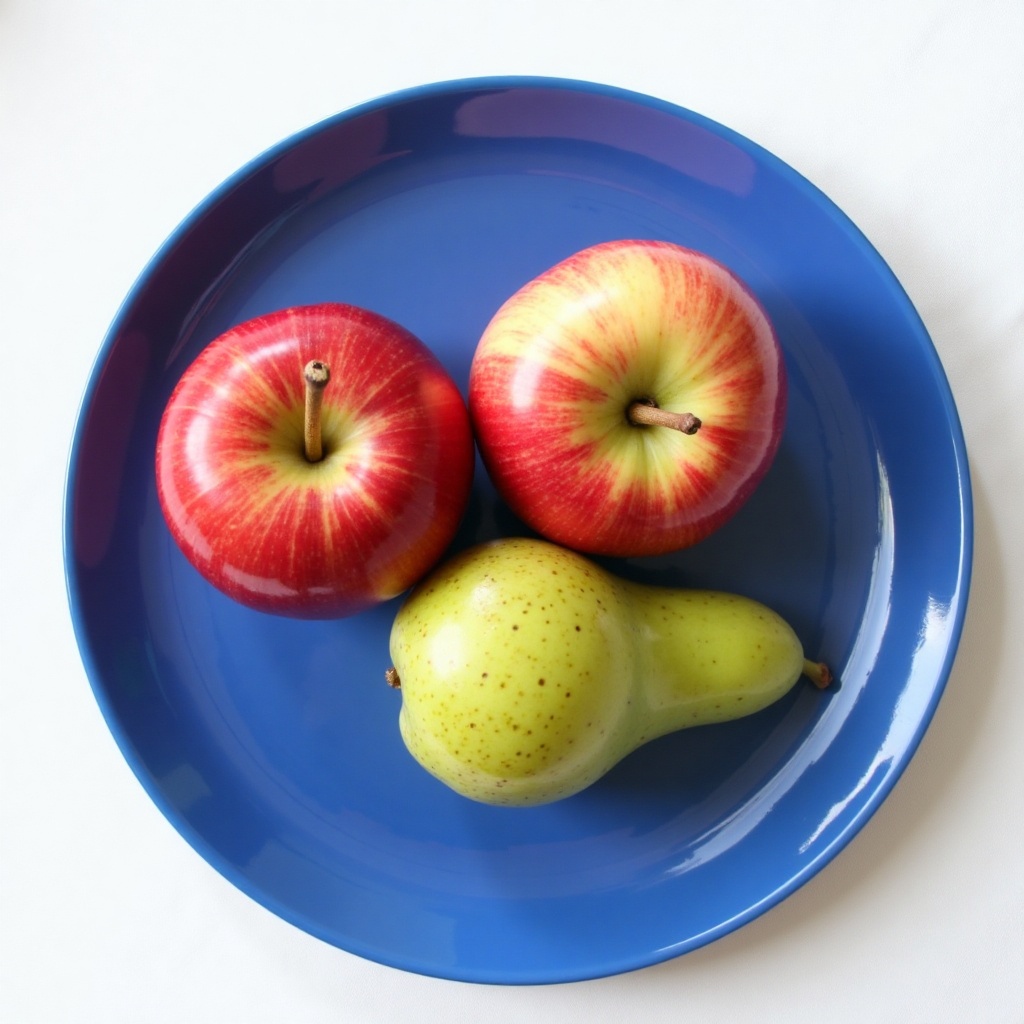 Luma Photon: Three red apples and one green pear arranged in a single row on a blue plate, top-down view, white tablecloth